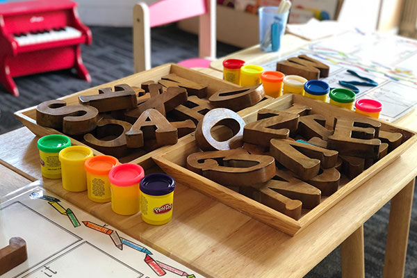 a child's playroom with a wooden table and toys.