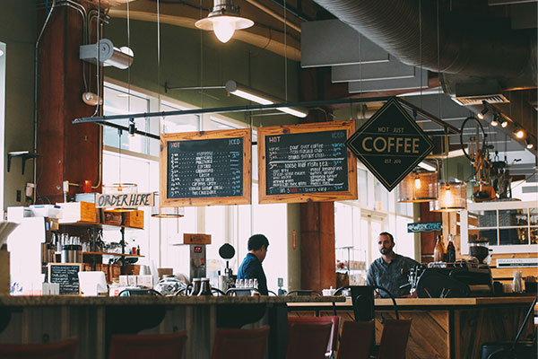 a coffee shop with people sitting at the counter.