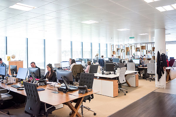 a group of people sitting at desks in an office.