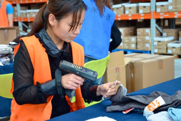 a woman in an orange vest is looking at a piece of paper.