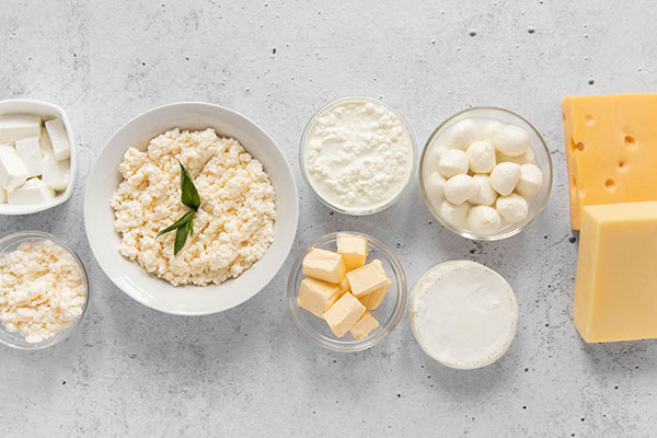 a table topped with bowls of cheese and other foods.