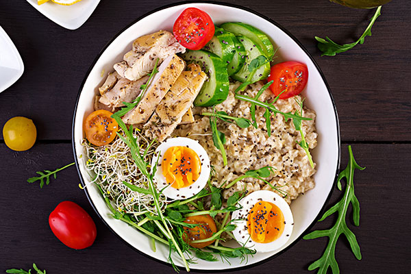 a bowl of food with eggs and vegetables.