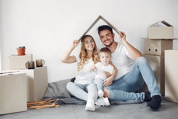 a man and woman sitting on the floor with a baby.