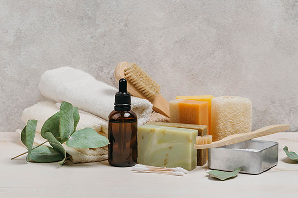 a bunch of soaps, soap bars, and a brush on a table.