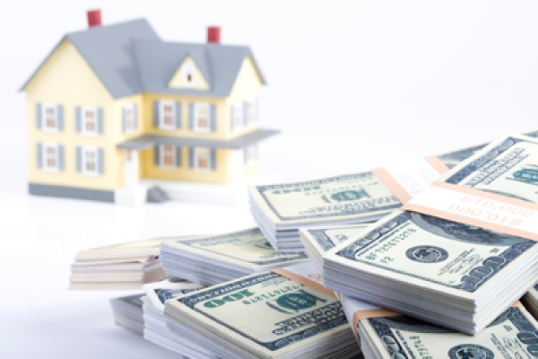 a pile of money sitting in front of a house.