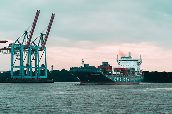 a large boat in the water near a large ship.